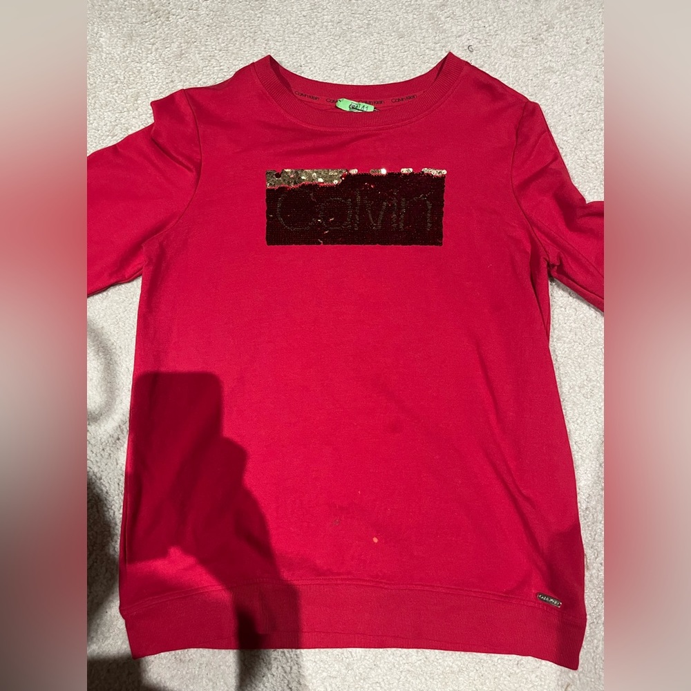 Calvin Klein on front of shirt w/shimmer of red.  Size S, worn twice.